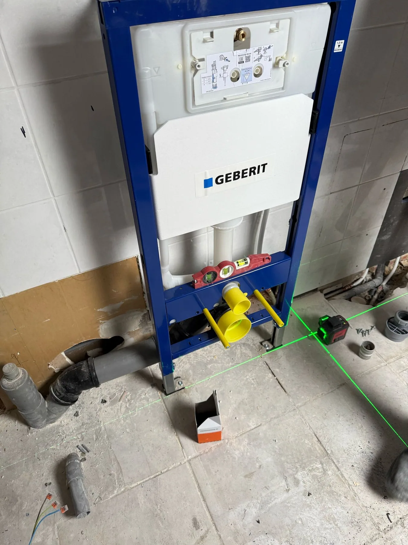 Geplaatst inbouwreservoir voor een hangtoilet, uitgelijnd met een laserlijn, nog zonder voorzetwand