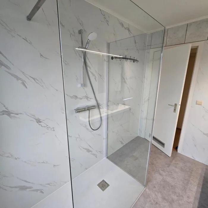 Marmerlook licht: Ruime inloopdouche met glazen wand, thermostaatkraan en witte marmerlook wandpanelen