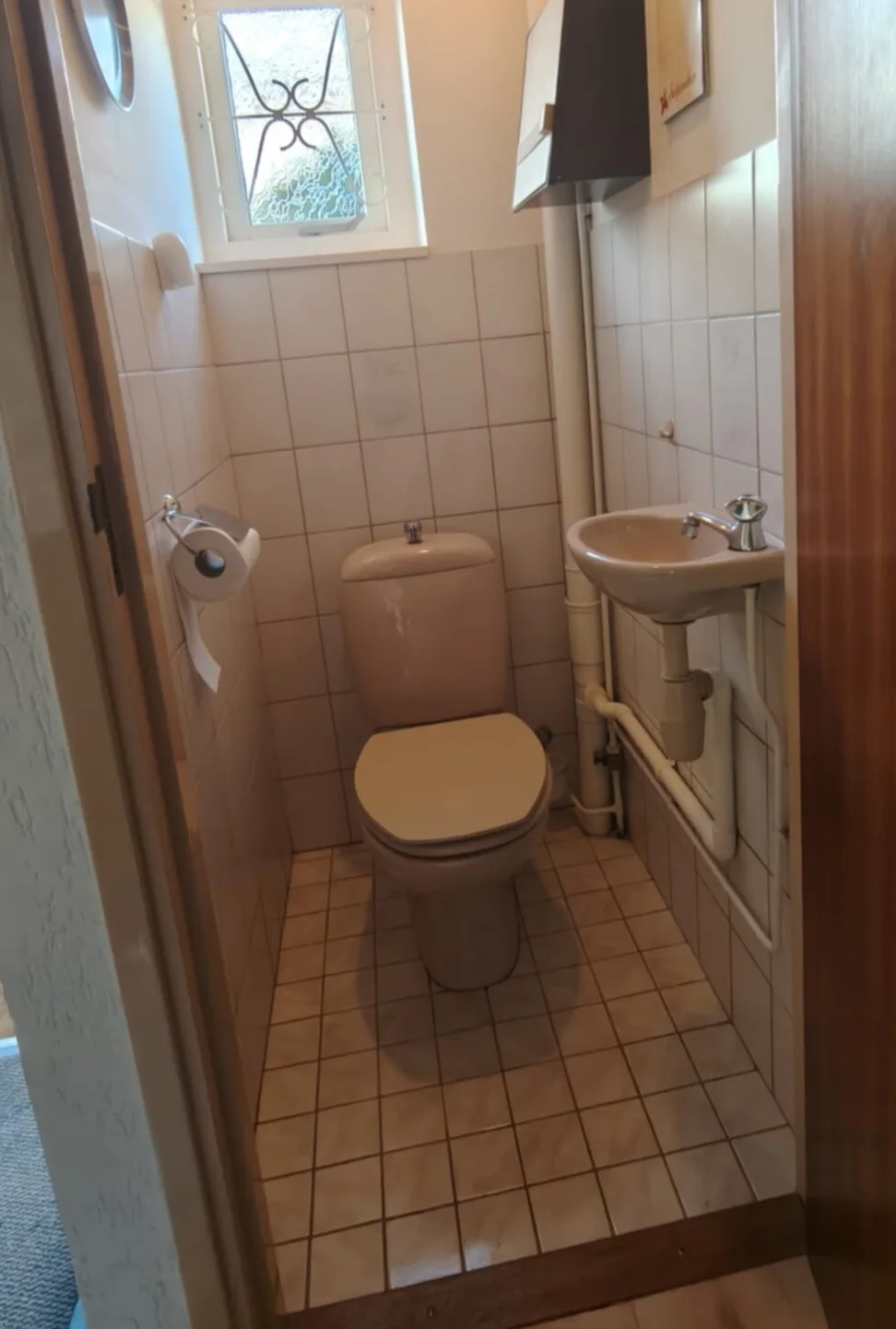 Voor: toiletruimte met staand toilet, fonteintje en kleine tegels